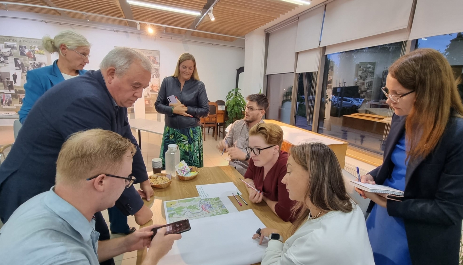 vairaki cilvēki ap galdu, notiek diskusija